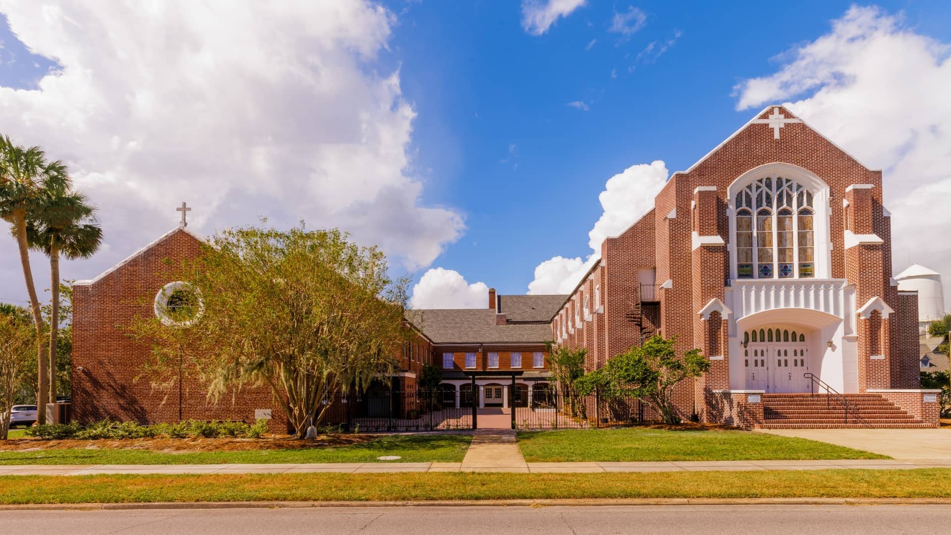 A brick church with a grassy lawn